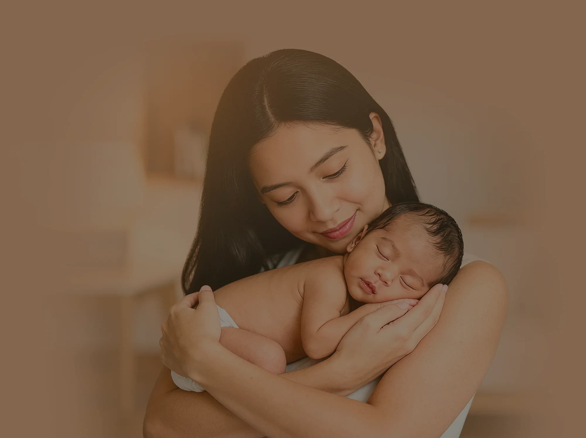 A mother gently holding her sleeping newborn baby